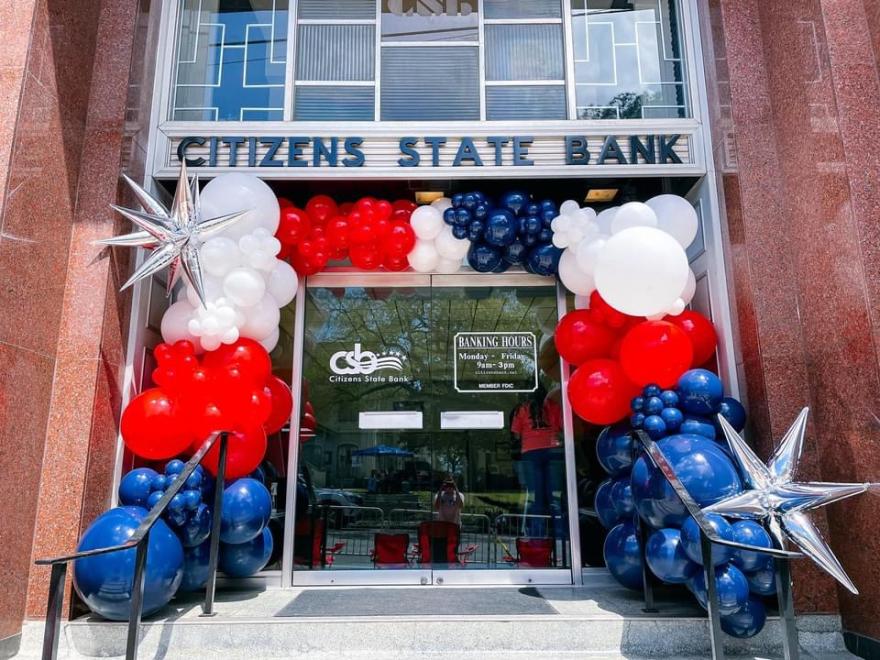 entrance to bank with large balloons around doors