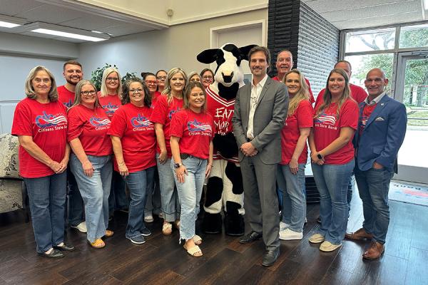 group photo with bank employees wearing red bank shirts