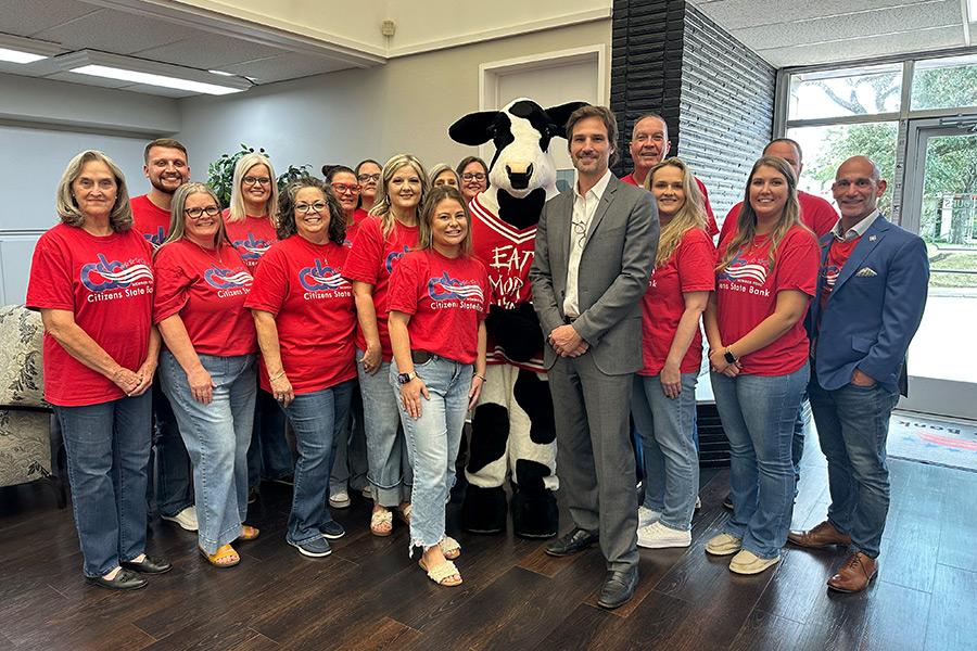 group photo with bank employees wearing red bank shirts