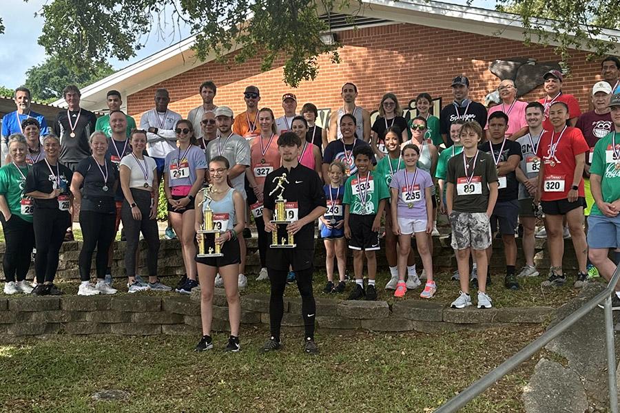 group photo of footrace runners and winners holding trophies