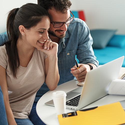 A couple looking at a laptop.