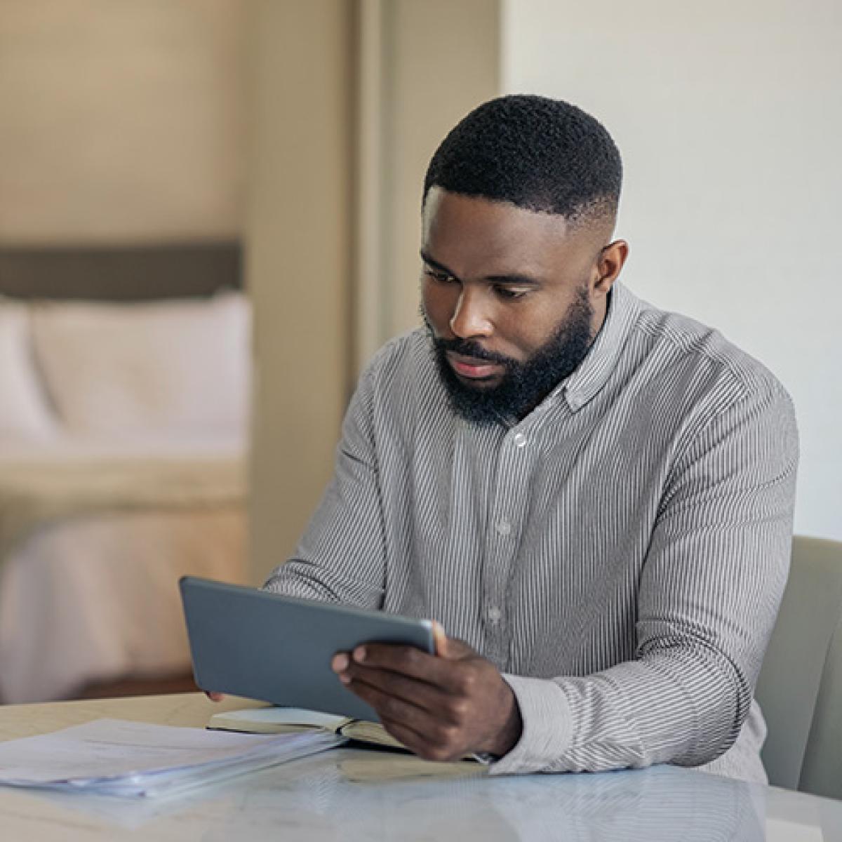Man is looking at his tablet.