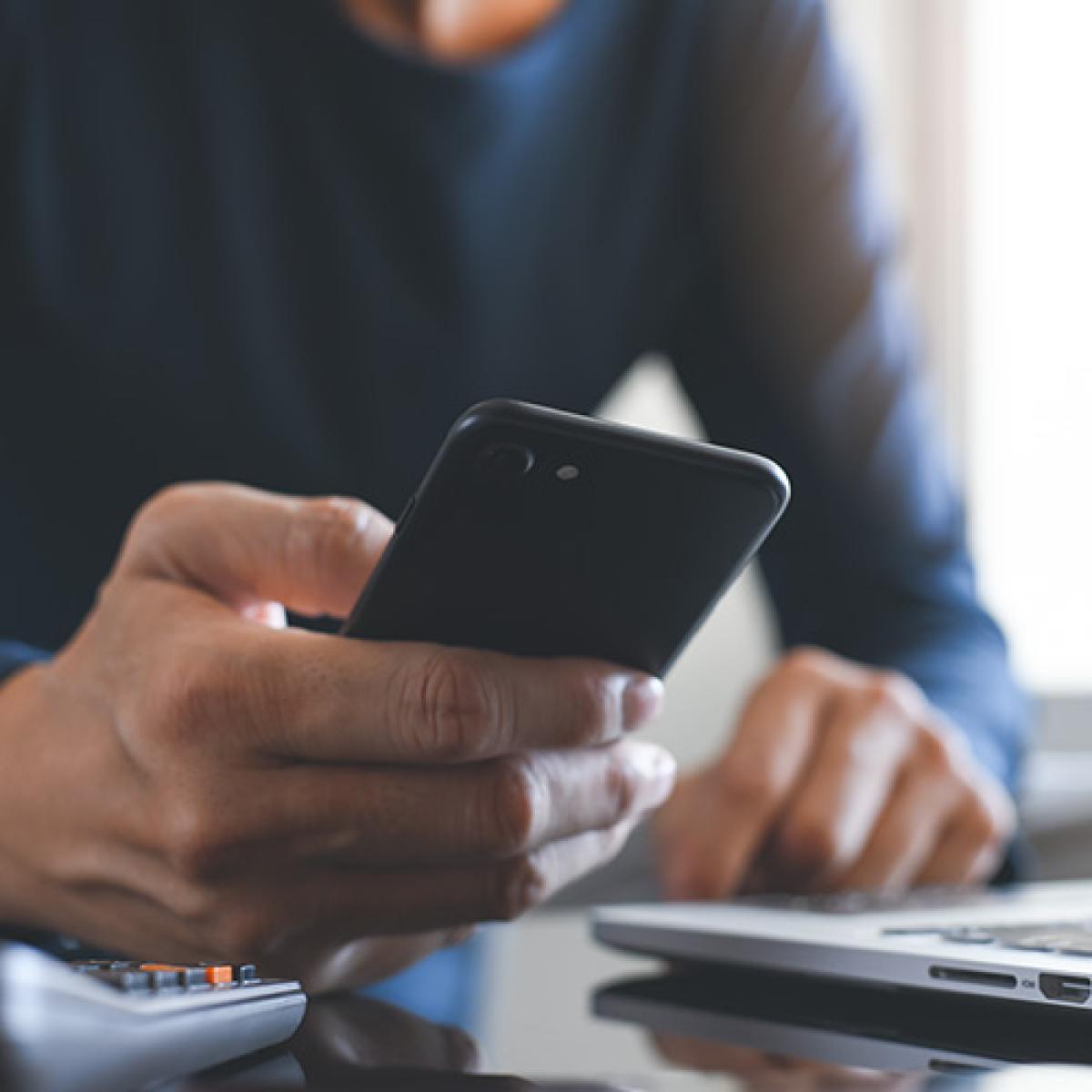 A closeup of a man's hand holding a phone.