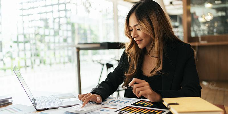 Woman looking over documents with charts.
