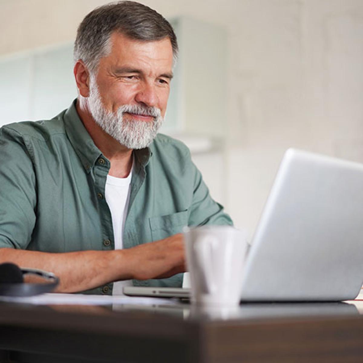 A man looks at his laptop.