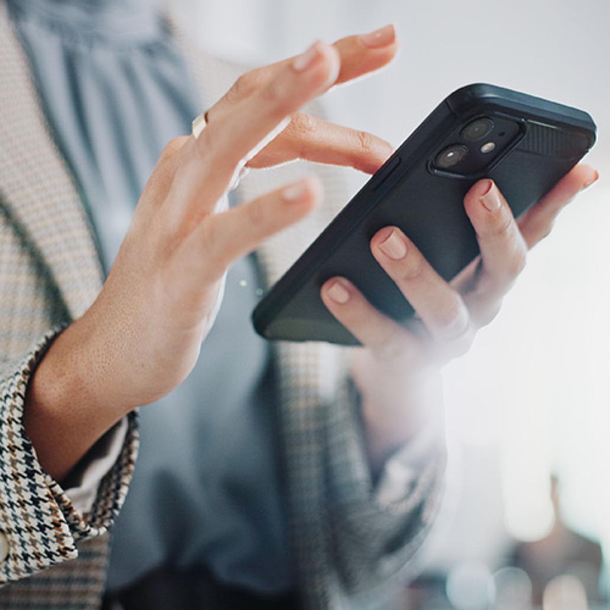 A close-up of hands holding a phone.